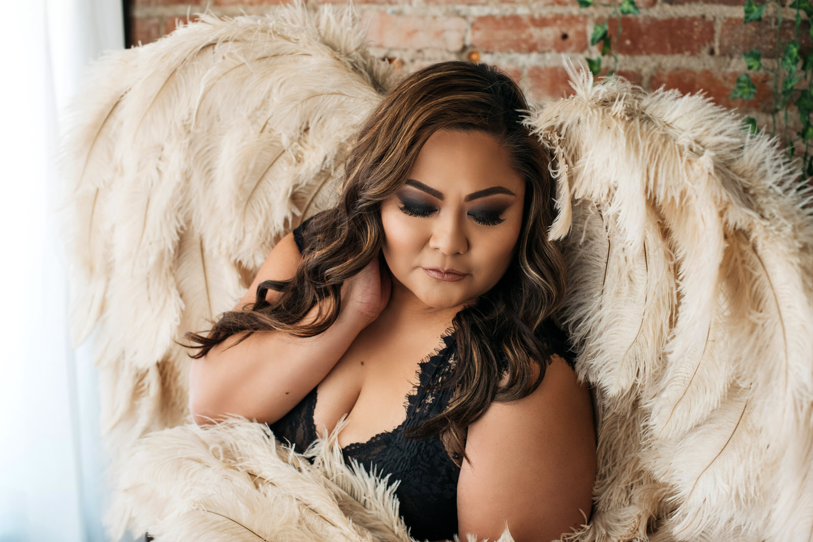 brunette in black body suit is oversized angel wings